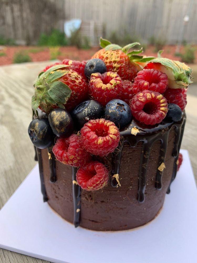 drip chocolate cake with lots of berries