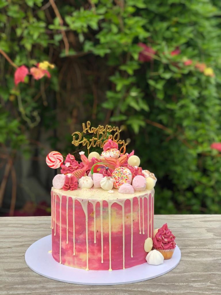 rainbow drip cake with hbd party popper