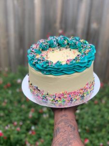 white cake with green icing and candies